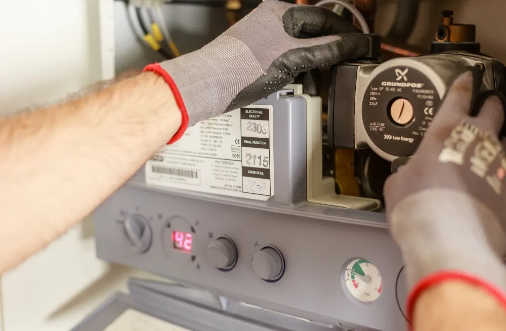 Fridge technician repairing a refrigeration compressor with specialized tools – Expert fridge repair service in Dubai.