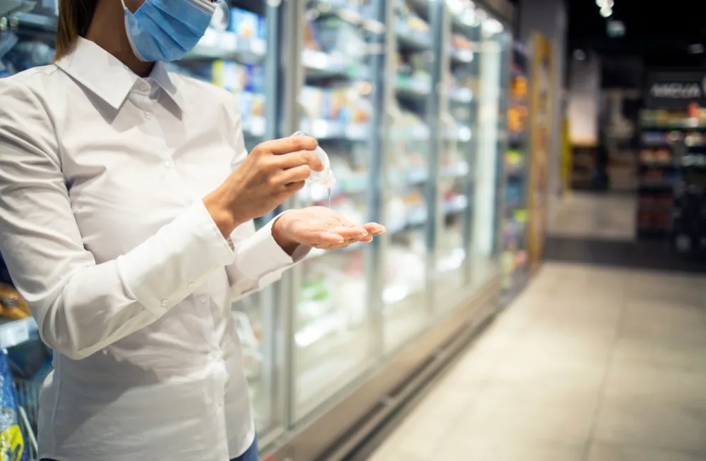 Chiller technician sanitizing hands before commercial chiller repair in Dubai supermarket
