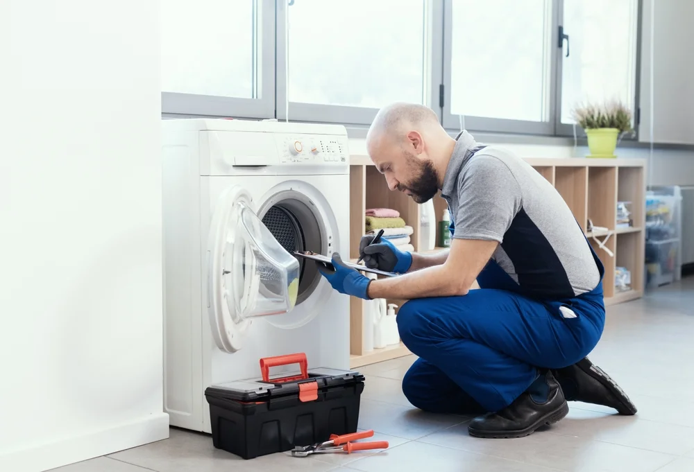 Technician from Prime Pro Technical repairing washing machine at home in Dubai.