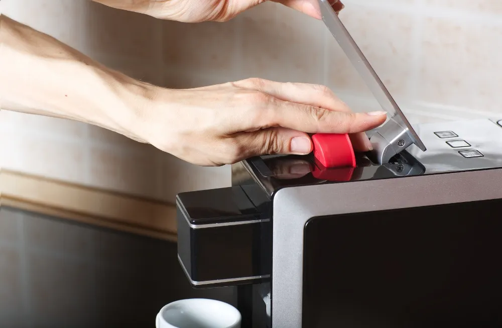 Technician repairing a coffee machine, resolving boiler and steam wand issues in Dubai.
