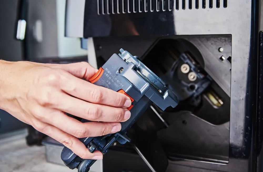 Technician handling a coffee machine component, showcasing advanced repair techniques like thermal imaging and pressure diagnostics in Dubai.
