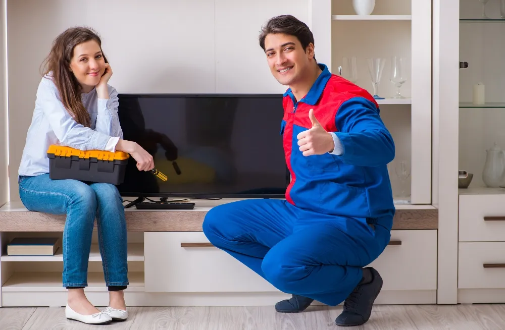 Happy customer with technician after successful tv repair Abu Dhabi service at home