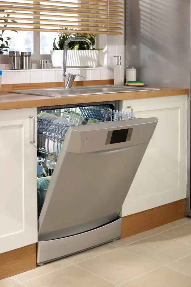 Professional technician repairing dishwasher in modern kitchen