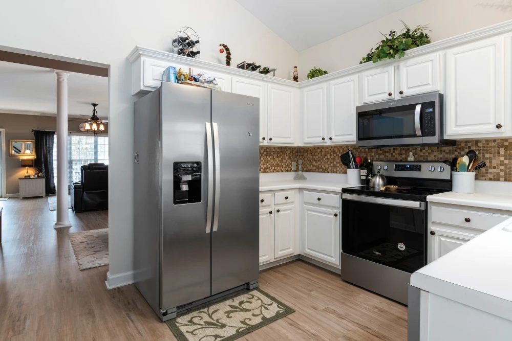 Technician inspecting refrigerator cooling fault in Sharjah home