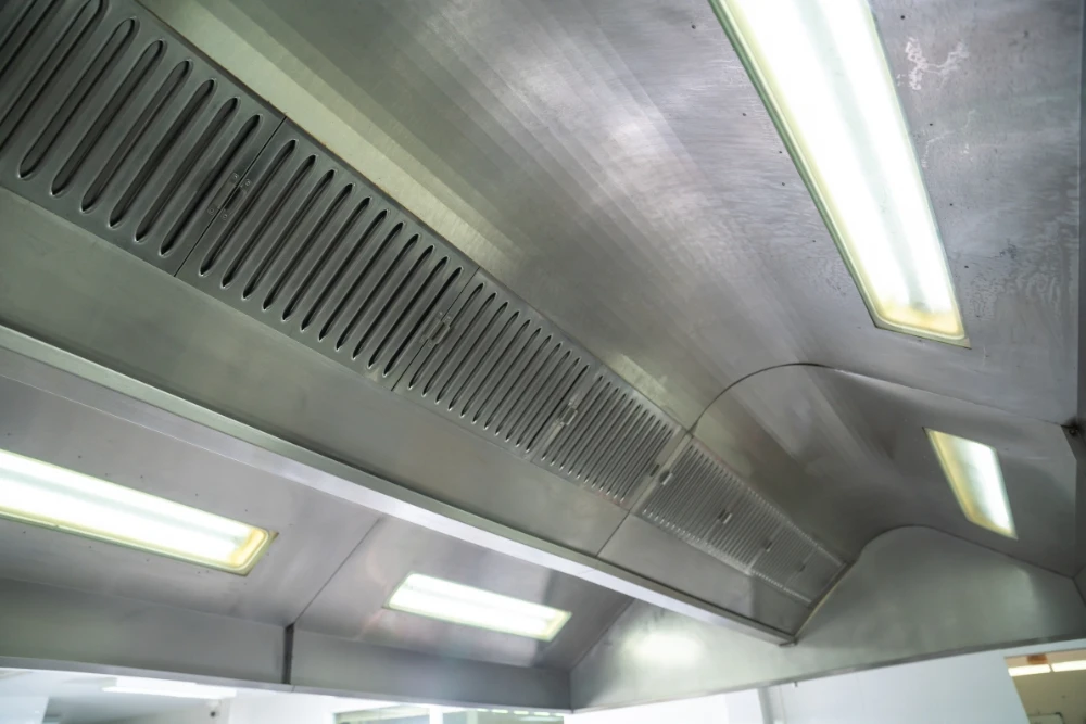 Professional technicians inspecting commercial kitchen hood ventilation system in UAE